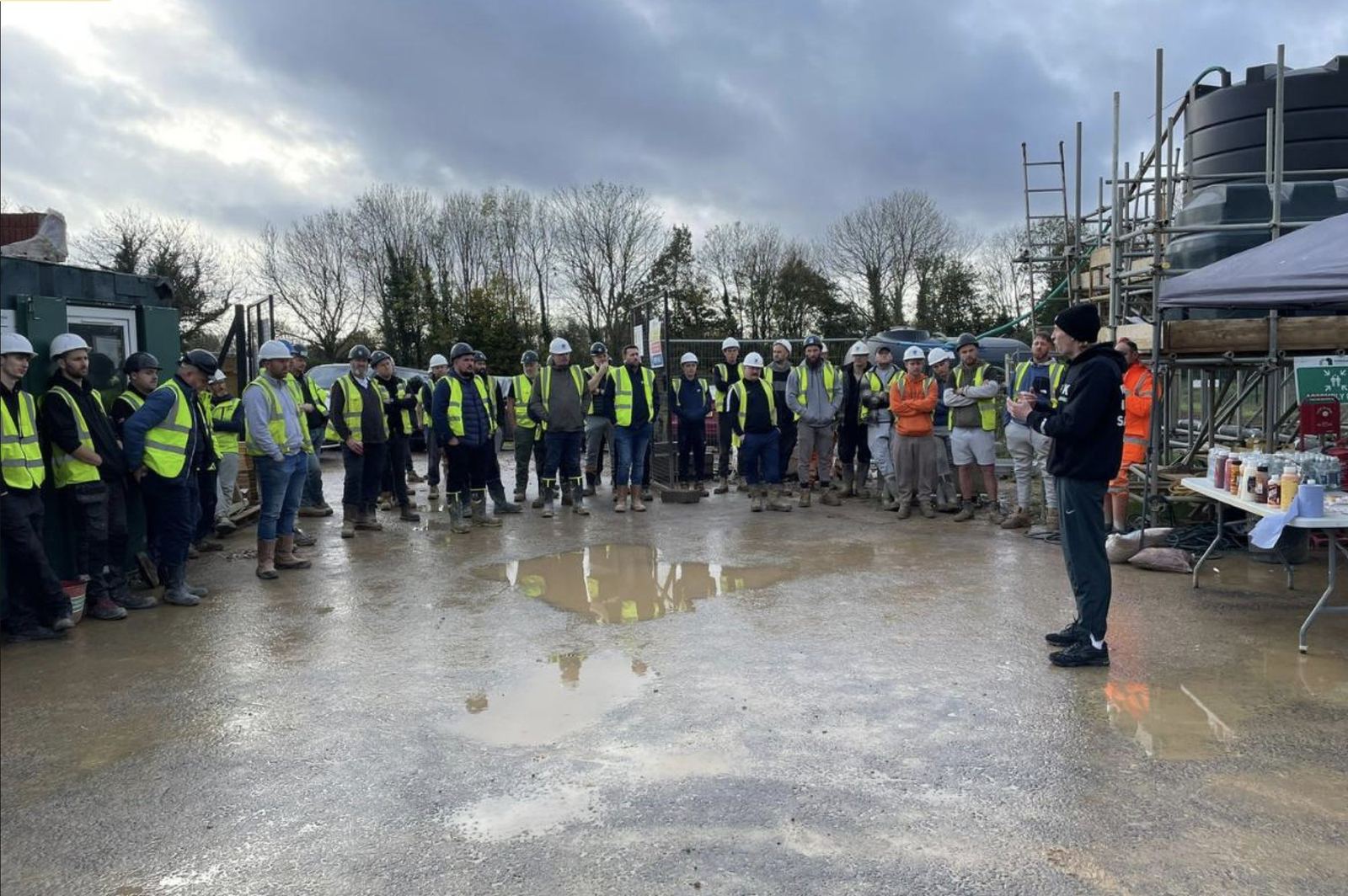 SPEAK founder Alfie Ruffell addressing a full site team gathered on a construction site during a toolbox talk